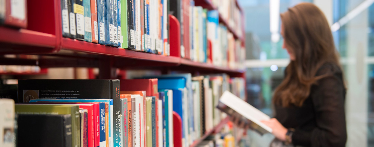 Étudiante qui lit dans une bibilothèque